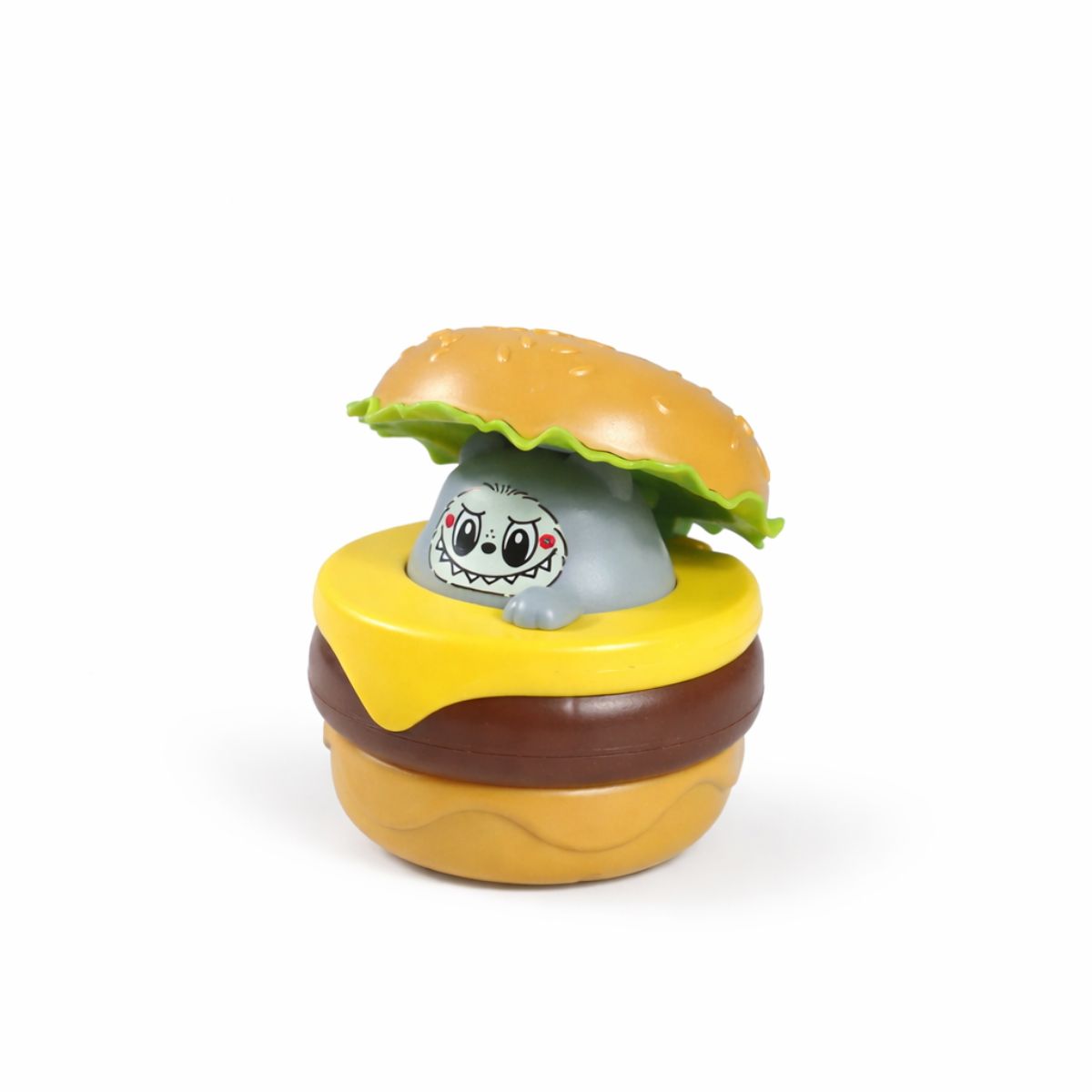 A plastic toddler toy shaped like a hamburger with a grey cartoon character peeking out from the center.