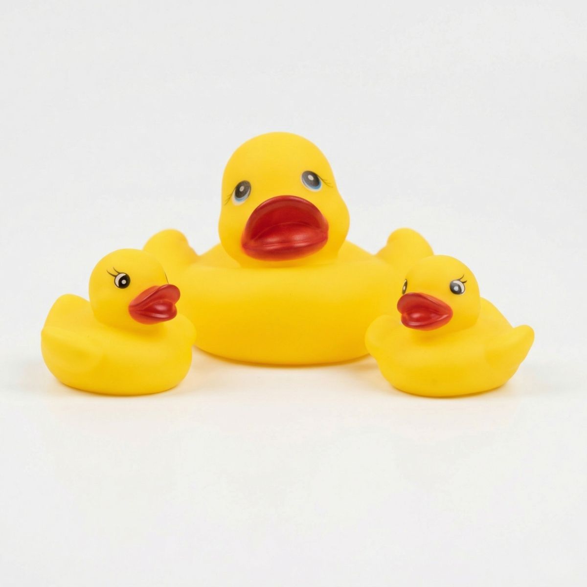 A classic yellow rubber duck family featuring one large parent duck and two smaller baby ducks sitting together.